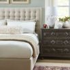 A modern bed with a soft and padded, deep buttoned back and upholstered cream finish 