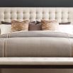 A sumptuous bed with a padded deep buttoned back and cream finish