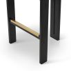 A luxury counter stool with a red and orange velvet upholstery and brass detailing