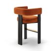 A luxury counter stool with a red and orange velvet upholstery and brass detailing