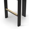 A luxury bar stool with a striking vibrant upholstery and brass detailing