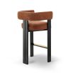 A luxury bar stool with a striking vibrant upholstery and brass detailing