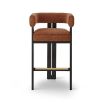 A luxury bar stool with a striking vibrant upholstery and brass detailing