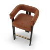A luxury bar stool with a striking vibrant upholstery and brass detailing
