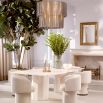 A stylish dining chair with a luxury beige upholstery and unique silhouette