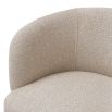 A stylish dining chair with a luxury beige upholstery and unique silhouette