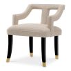 A stylish dining chair with a distinctive silhouette and luxury beige upholstery