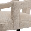 A stylish dining chair with a distinctive silhouette and luxury beige upholstery
