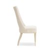 Neutral upholstered dining room chair with peak-through lower back