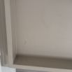 Pale grey table with four solid legs and a bordered top surface