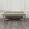 Pale grey table with four solid legs and a bordered top surface