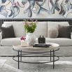 Round coffee table with a black metalwork frame and pale edged top