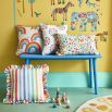 Striped multicoloured throw cushion with frilled edges.