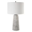 This tapered ceramic lamp has a distressed off-white finish, brushed nickel accents, and a white linen shade, adding timeless elegance to any space.