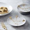A gorgeous set of four white and speckled gold porcelain plates.