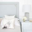 Luxury blue grey linen bed with an elegant tall headboard, with an art deco studding design