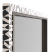 Delicate mosaic of black and white resin adorn a rectangular mirror