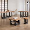 The Coliseum Dining Table features a cork table top supported by ebonized oak arches, blending modern design with organic materials and seating up to eight.