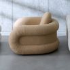 The Pompidou Lounge Chair is a deep, cozy cocoon with a tubular framework, upholstered in Valais Latte bouclé for ultimate comfort.