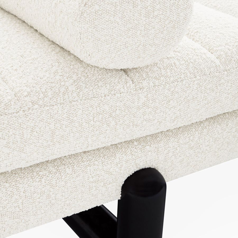 The Aspen Daybed features a lozenge-inspired design with ebonized legs and channelled bouclé cushions, offering style and comfort for any space.
