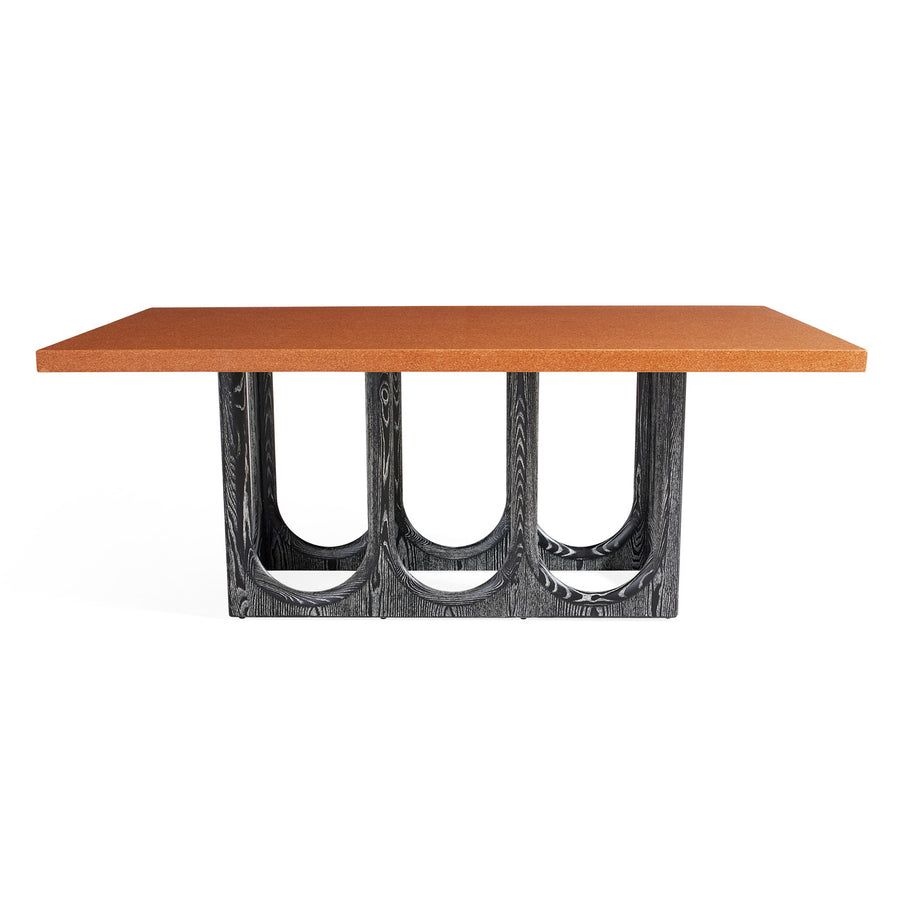 The Coliseum Dining Table features a cork table top supported by ebonized oak arches, blending modern design with organic materials and seating up to eight.