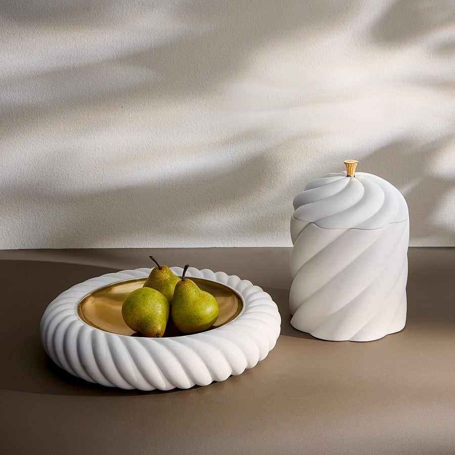 A sculptural, high-fired porcelain box with a luxe gold pull, perfect for adding elegance to any table or space.