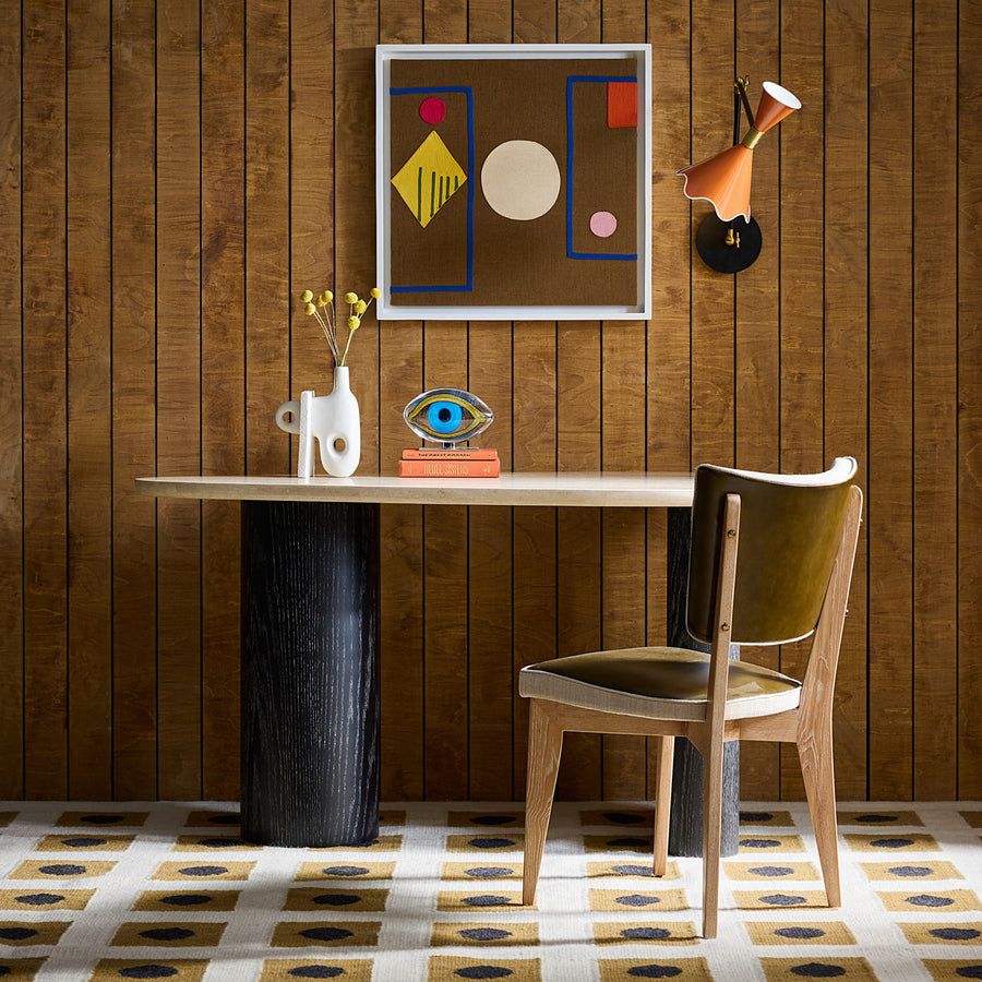 The Oeuf Travertine Desk blends mid century-inspired design with luxe materials, featuring a travertine top, ebonized oak supports, and hidden storage.