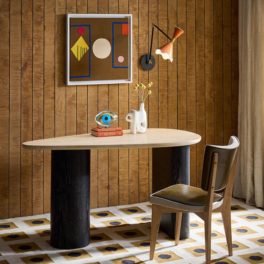 The Oeuf Travertine Desk blends mid century-inspired design with luxe materials, featuring a travertine top, ebonized oak supports, and hidden storage.