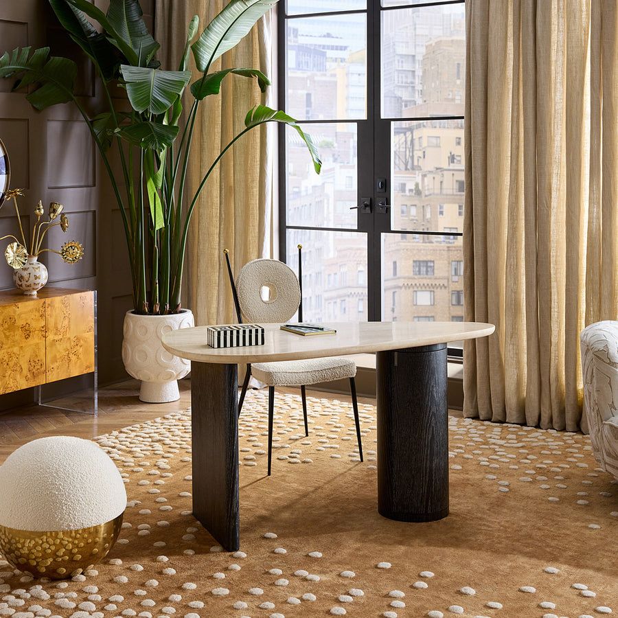 The Oeuf Travertine Desk blends mid century-inspired design with luxe materials, featuring a travertine top, ebonized oak supports, and hidden storage.