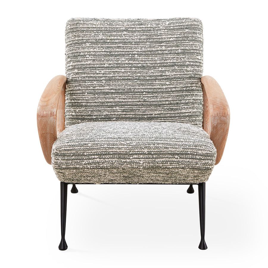 The Gainsbourg Lounge Chair is a vintage-inspired piece with a cushy seat, cerused ash wood arms, and blackened metal legs, perfect for pairing with a sofa.