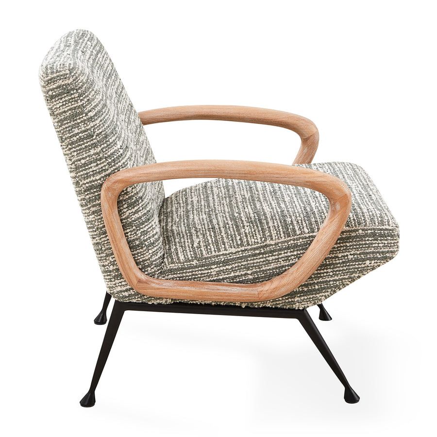 The Gainsbourg Lounge Chair is a vintage-inspired piece with a cushy seat, cerused ash wood arms, and blackened metal legs, perfect for pairing with a sofa.