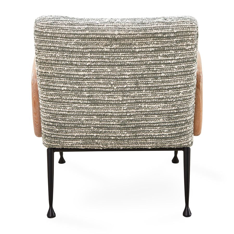 The Gainsbourg Lounge Chair is a vintage-inspired piece with a cushy seat, cerused ash wood arms, and blackened metal legs, perfect for pairing with a sofa.