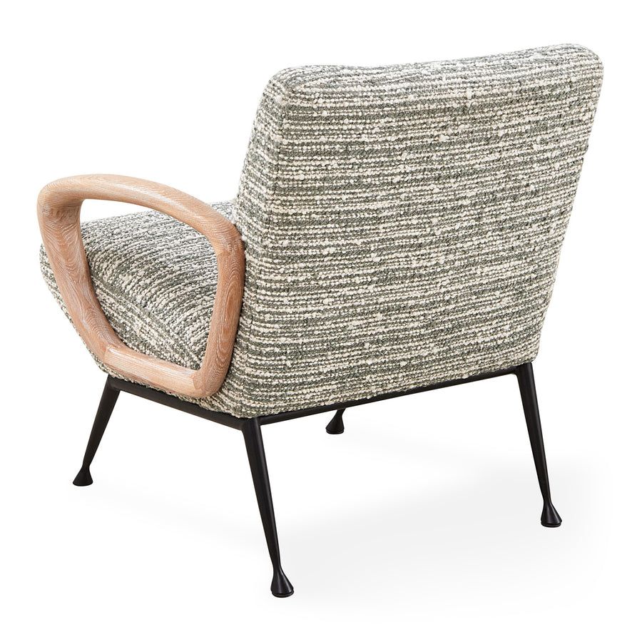 The Gainsbourg Lounge Chair is a vintage-inspired piece with a cushy seat, cerused ash wood arms, and blackened metal legs, perfect for pairing with a sofa.