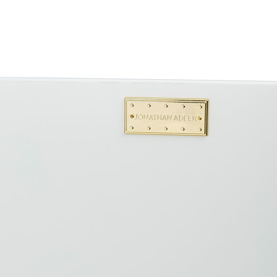 The Op Art Cabinet is a striking modernist piece with back-painted glass panels, polished brass accents, and adjustable interior shelving for functional elegance.
