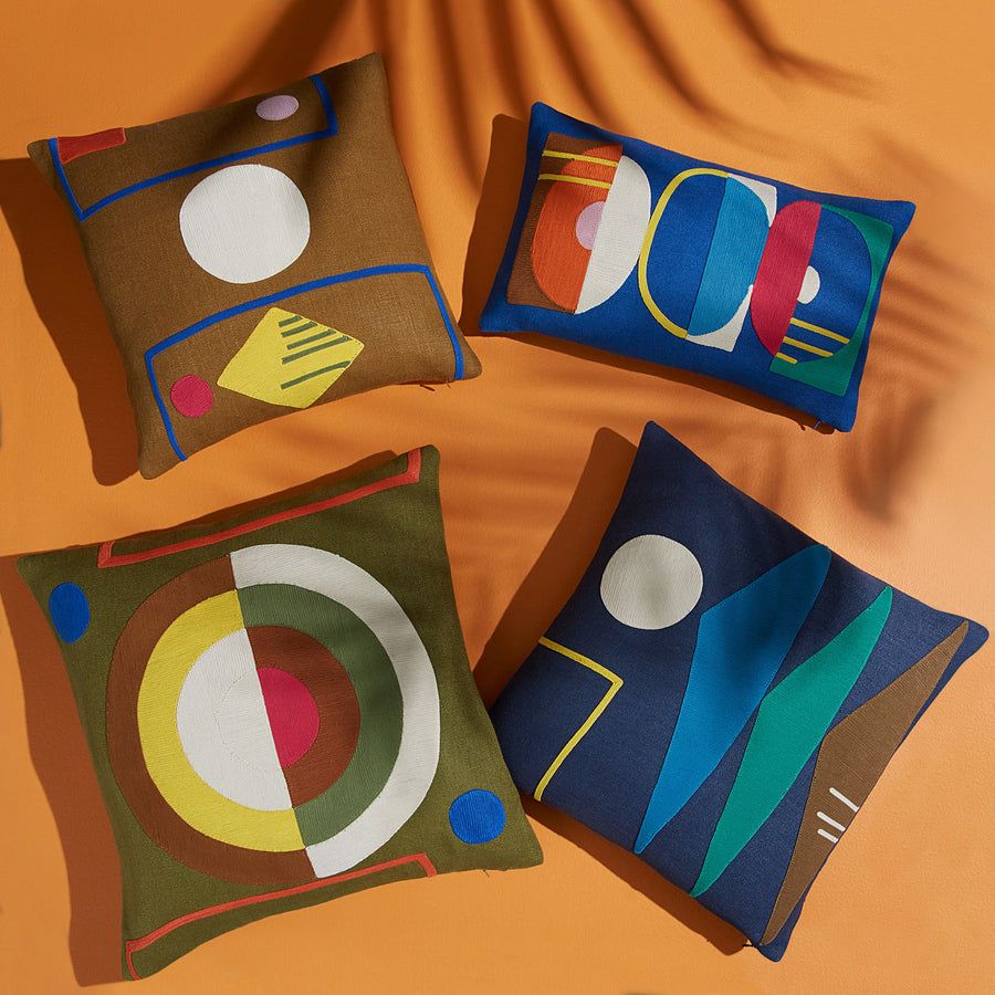 The Monterey Triangles Cushion showcases concentric cord embroidery on dyed linen, available in vibrant or luxe palettes for an eye-catching display.