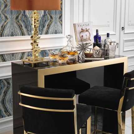 A glamorous bar by Eichholtz with a black glass exterior and gold finished frame