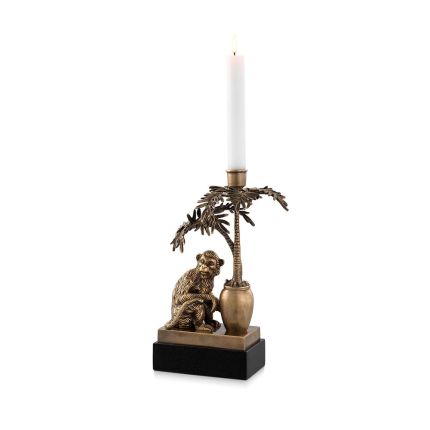 A charming brass candle holder with a decorative monkey and palm tree on a granite base.