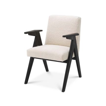 A classic shaped dining chair with contrasting black legs and white boucle upholstery