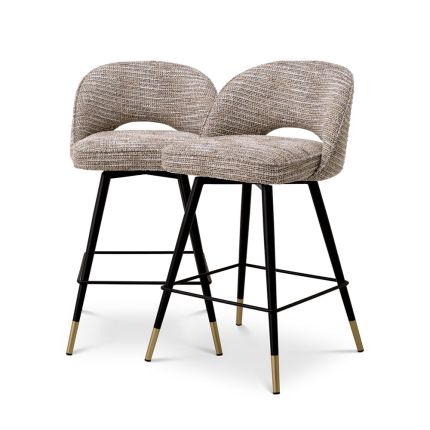 A luxury set of counter stools by Eichholtz with sumptuous upholstery and brass capped feet