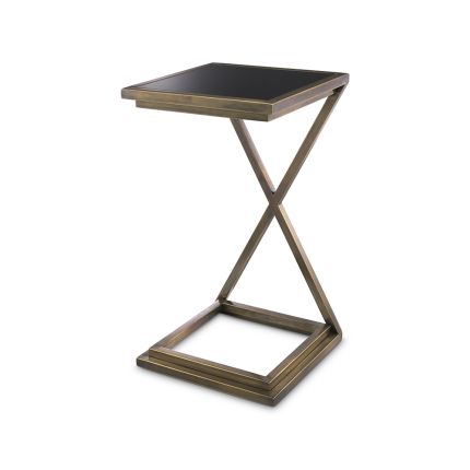 A stylish side table by Eichholtz with a cross-legged frame, vintage brass finish and black glass table top