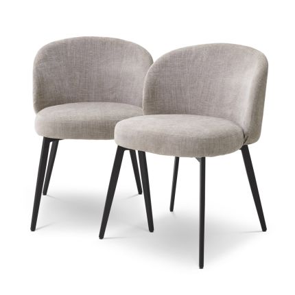 A set of chic dining chairs from Eichholtz with a gorgeous grey upholstery and black tapered legs 