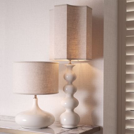 A sophisticated ceramic table lamp by Eichholtz with a bulbous base and unique shaped shade