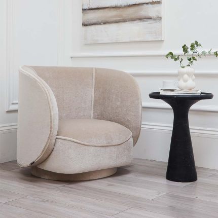 A luxurious exclusively sweetpea armchair with a curvaceous silhouette and a swivel base