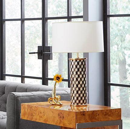 A stylish, porcelain table lamp with a chic geometric pattern and brass accents 