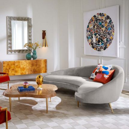 A gorgeous grey velvet sofa on brass legs.