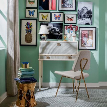 A regency inspired desk finished with sky blue raffia and ivory lacquered mahogany legs and frame.