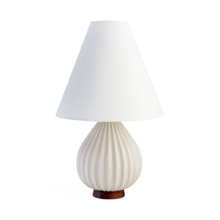 A sculptural side lamp with a grooved porcelain finish and walnut base