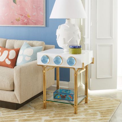 Futuristic side table with blue orb detail and polished brass finish