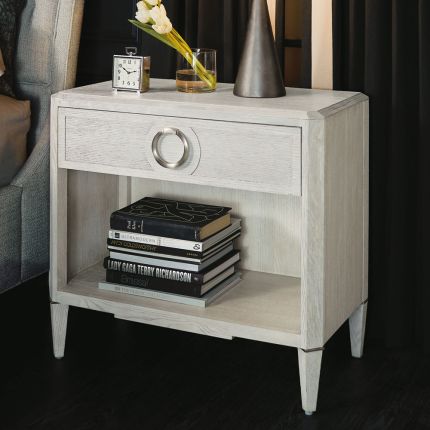A stylish natural wood bedside table with nickel hardware