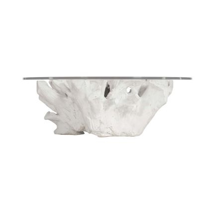 A white cast tree stump based coffee table with a glass top.